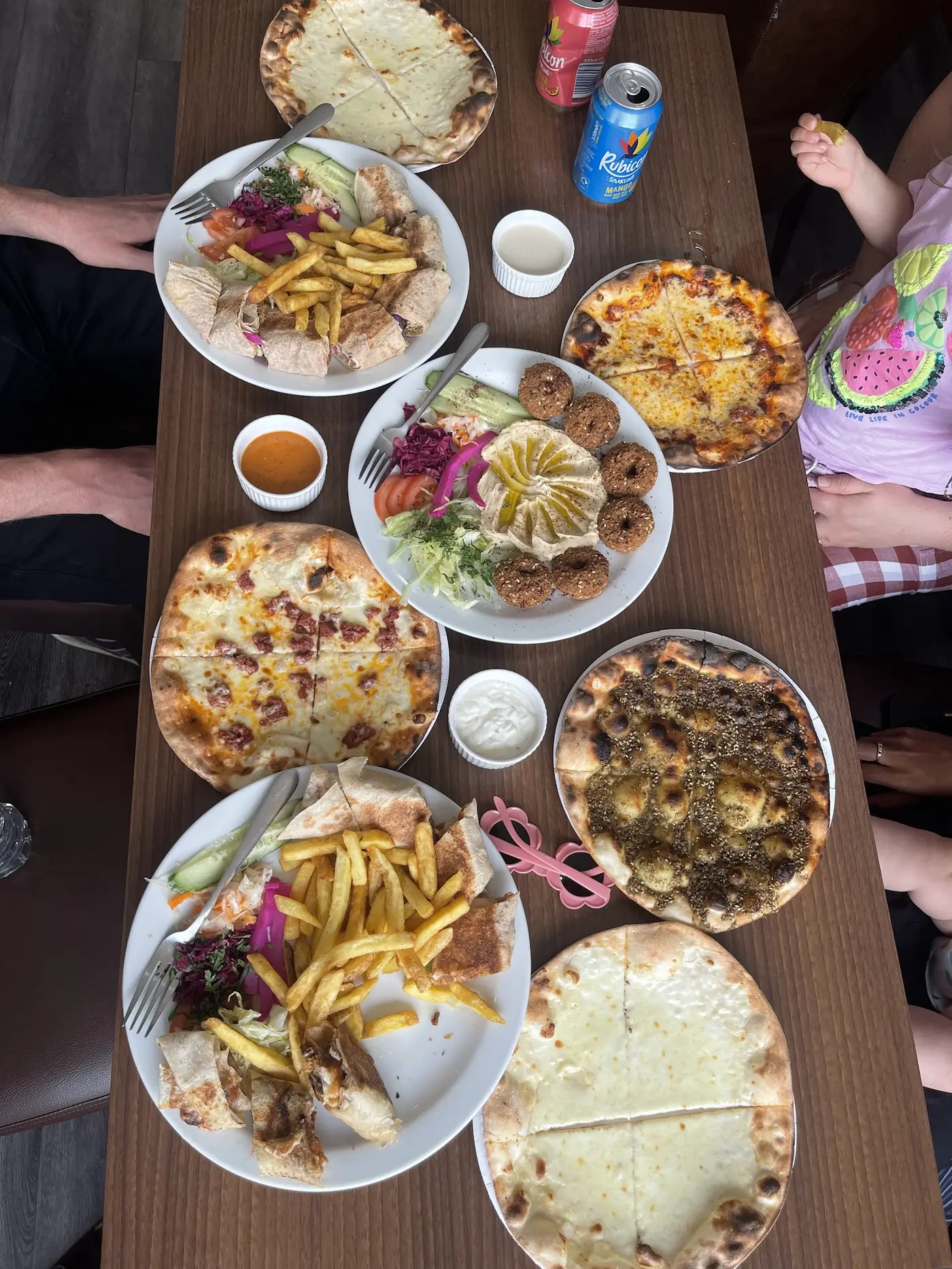 Haven Shawarma family spread — manakish, falafel platter with hummus, fresh pizzas and shawarma wraps